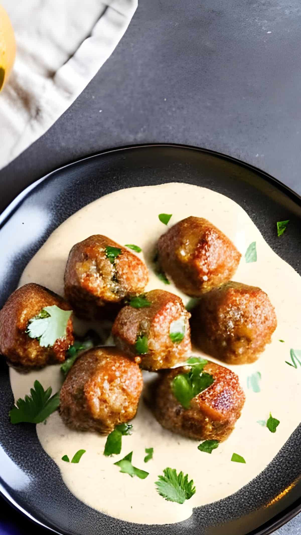 Eine Nahaufnahme von einem dunklen Teller mit Köttbullar.