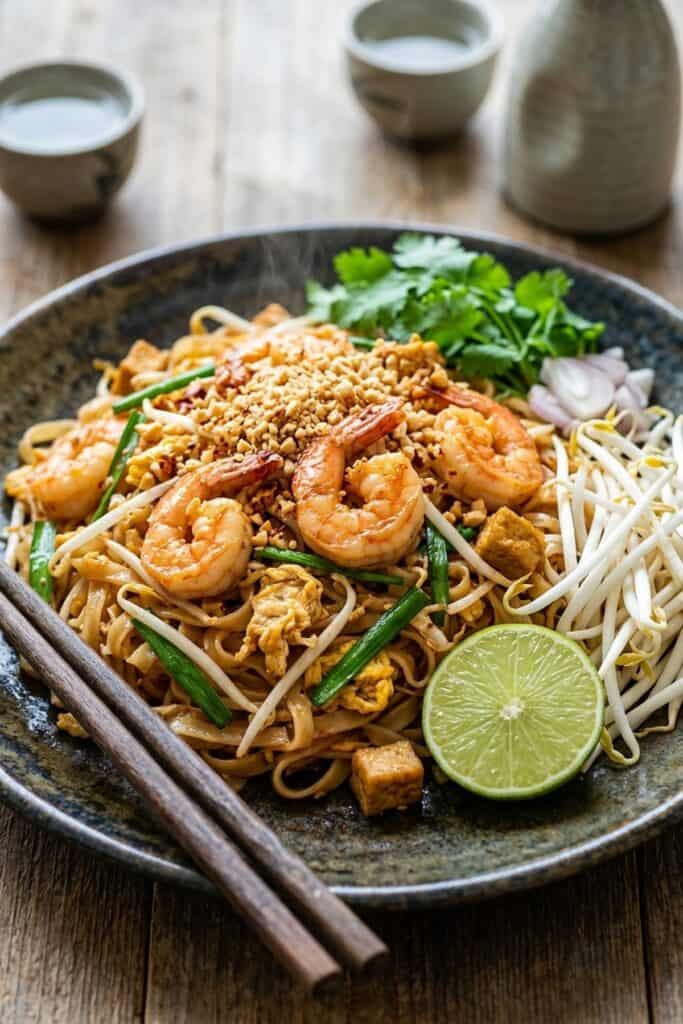 Authentisches Pad Thai mit Garnelen serviert im rustikalen Teller bei sanftem Tageslicht