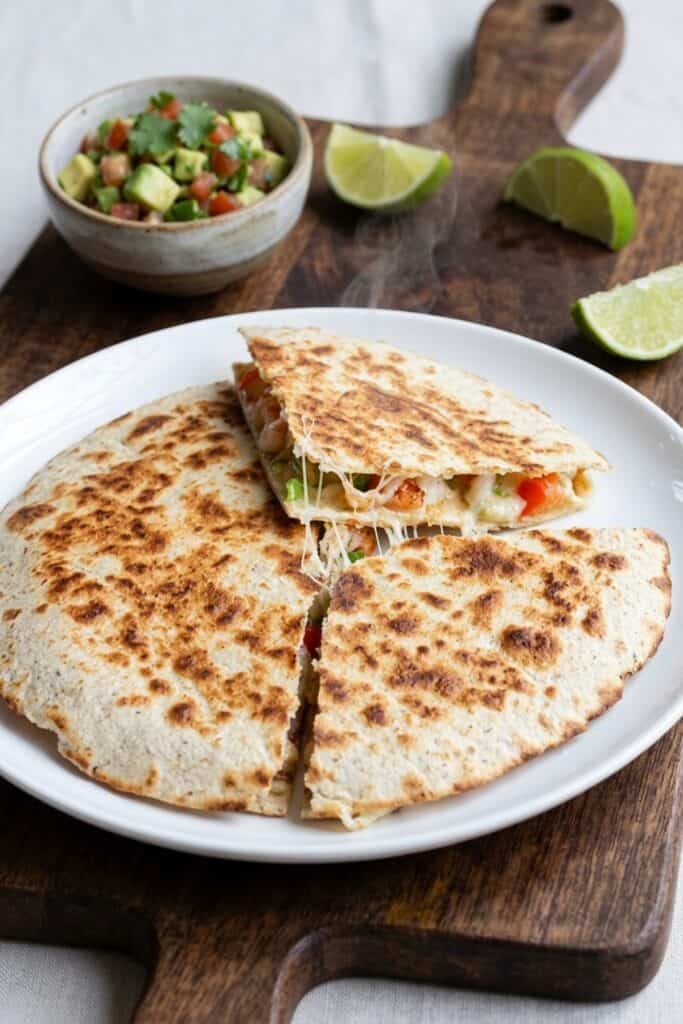 Knusprige Garnelen-Quesadillas mit frischer Tomaten-Avocado-Salsa serviert im rustikalen Teller bei sanftem Tageslicht