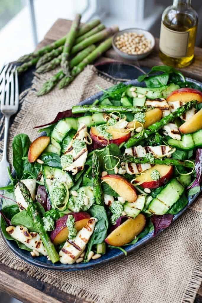 Gegrillter Halloumi-Pfirsich-Salat mit frischem Zitronen-Pesto serviert im rustikalen Teller bei sanftem Tageslicht