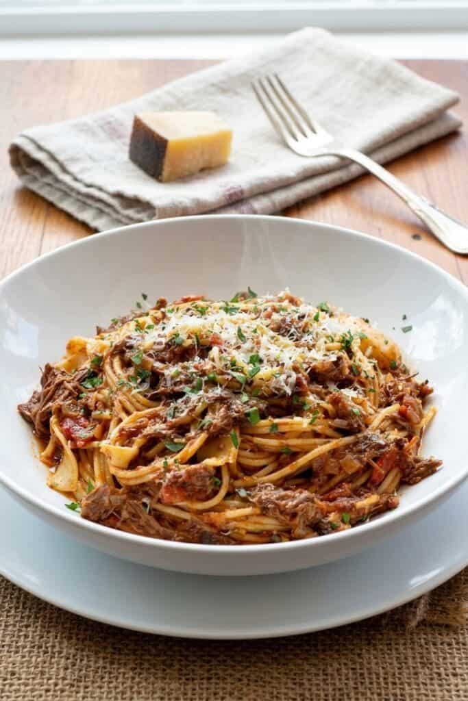 Schnelle Pasta mit zartem Rinderbacken-Ragù serviert im rustikalen Teller bei sanftem Tageslicht